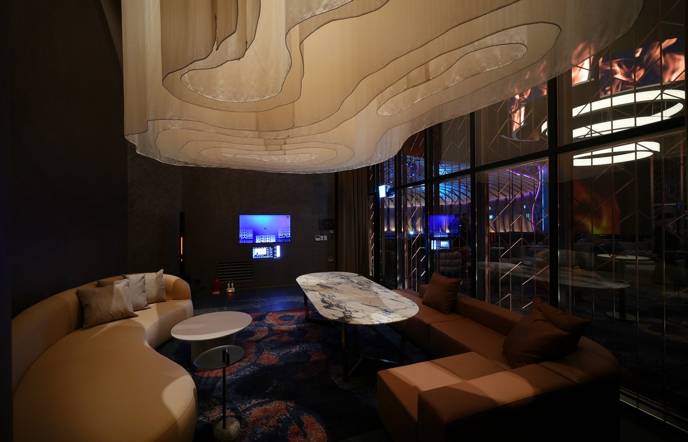 A private lounge room at Ultra Lounge, featuring karaoke, sculptural seating, marble tables, and soft ambient lighting designed for intimate gatherings and exclusive hosting.